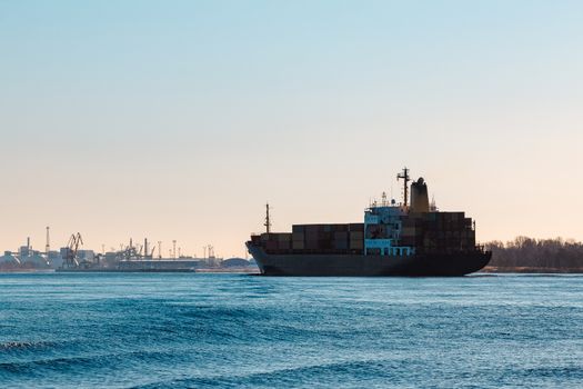 Modern black container ship moving from Baltic sea