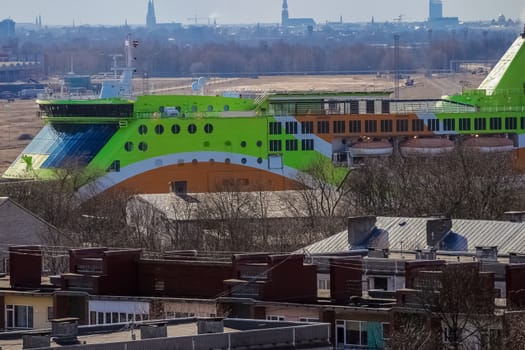 Green cruise liner. Passenger ferry sailing past the Riga city