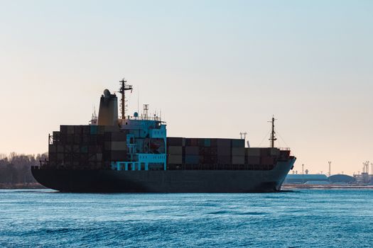 Modern black container ship moving from Baltic sea