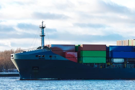 Modern grey container ship moving in still water