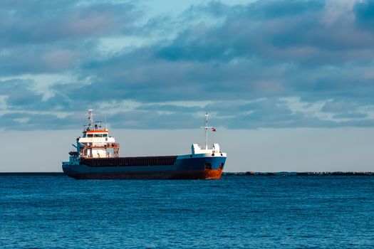 Blue bulk carrier sailing in still water
