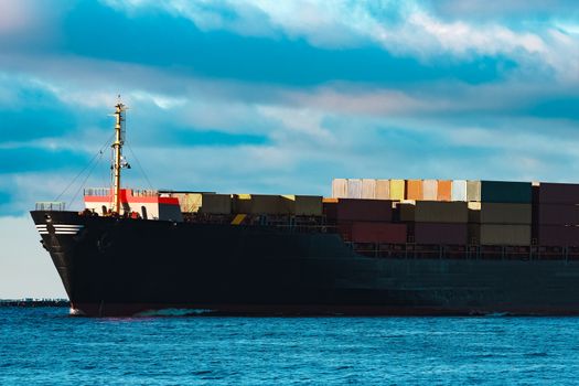 Modern black container ship moving from Baltic sea