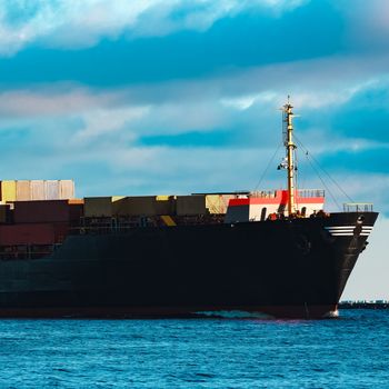 Modern black container ship moving from Baltic sea