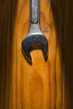 New metal wrench on a wooden background