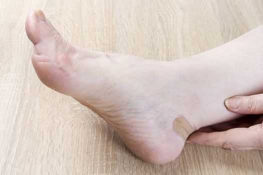 Female foot and hand close-up on a wooden background