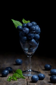 Blueberries with leaves in small glass