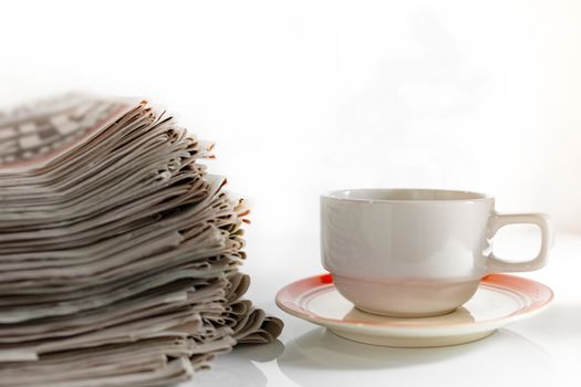 Newspapers and Coffee on the white table .