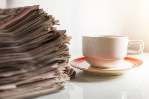 Newspapers and Coffee on the white table .
