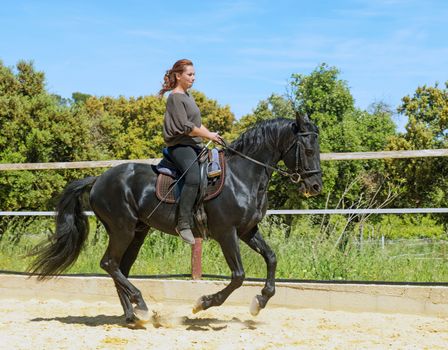 riding woman on a white stallion training in dressage