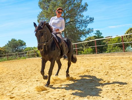 riding woman on a white stallion training in dressage