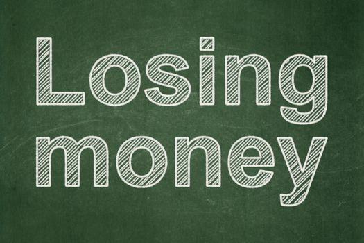 Money concept: text Losing Money on Green chalkboard background