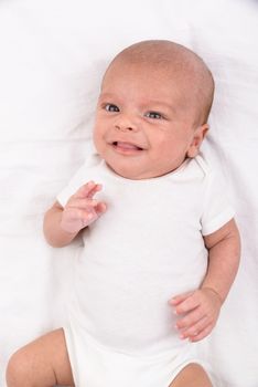 Mixed race south asian and caucasian newborn baby on white sheet