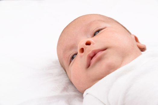 Mixed race south asian and caucasian newborn baby on white sheet