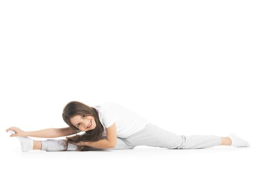 Girl doing split exercise isolated on white background
