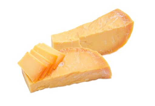 Two pieces and several thin slices of Dutch cheese Beemster on a light background
