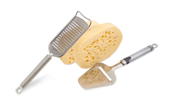 Cheese slicer and cheese grater with two pieces of the semi-hard Swiss-type cheese on a light background
