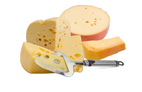 Cheese slicer against the background of the several pieces of the hard and semi-hard cheese on a light background
