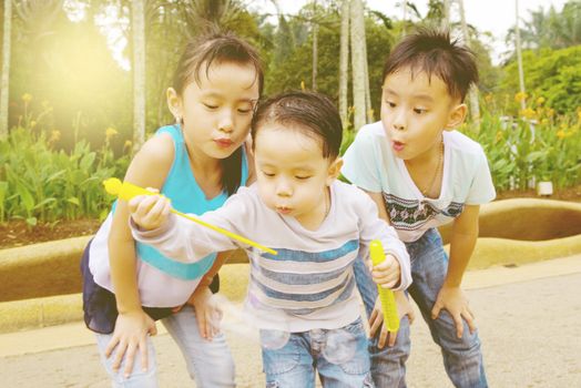 Asian kids blowing bubbles outdoor