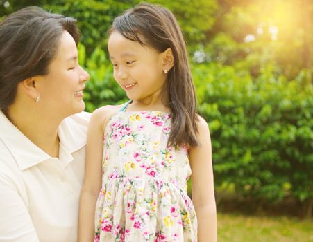 Outdoor portrait of asian mother and her lovely daughter