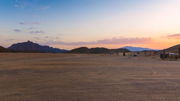 Wonderful landscape,Arabian desert of stone, Egypt with mountains at sunset.To the right of the desert nomad huts,