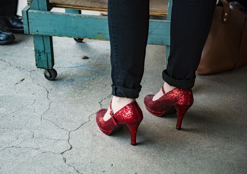 Woman wearing black pants and red high heel shoes in old town in the US