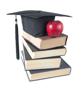 Black graduate hat, stack of big books and red apple, isolated on white background