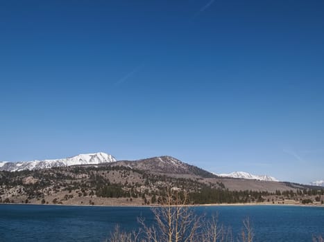 Beautiful lake, snow mountain and pine tree with blue sky in California, USA