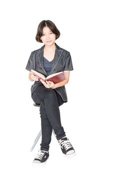 Asian woman reading a book sitting on chair Isolated on white background