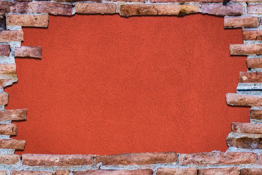 Ancient red brick wall with a hole over a bakground red.