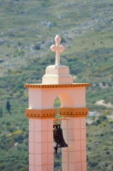 Outside bell of a Greek Orthodox church with the mountain in the background