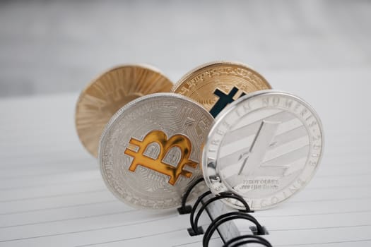 Digital currency physical silver and gold coins in notebook.