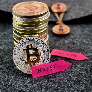 Cryptocurrency physical silver bitcoin coin and pink arrows concept.