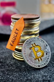 Digital currency physical silver bitcoin coin and faucet orange arrow.