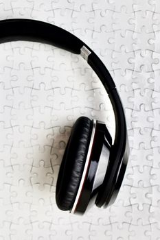 Black headphones on white puzzles