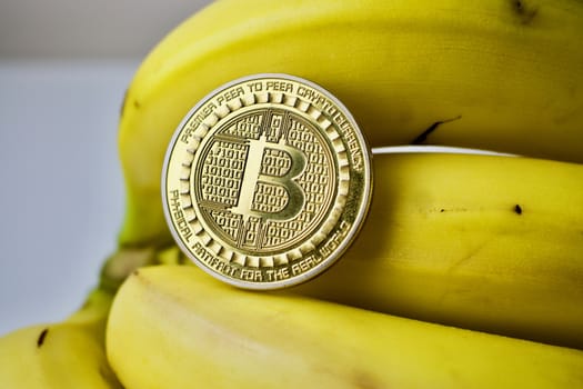 Gold bitcoin coin on fresh bananas