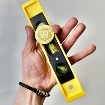 Level scale with bitcoin coin in hand