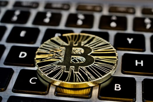 Cryptocurrency physical gold bitcoin coin on the keyboard