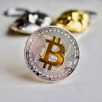 Digital currency physical silver bitcoin coin, and two gold and silver masks.