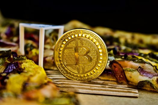Cryptocurrency physical gold bitcoin coin near the pizza