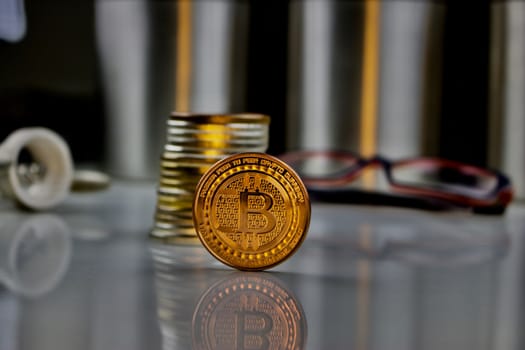 Digital currency physical gold bitcoin coin near glasses