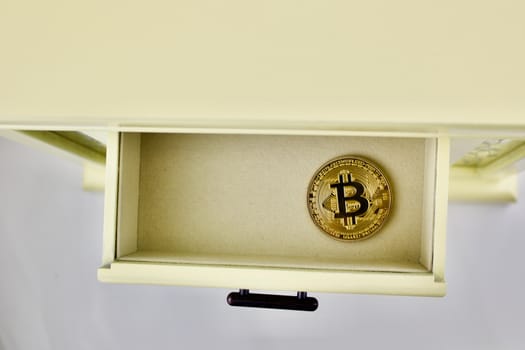 Gold bitcoin physical coin in yellow drawer