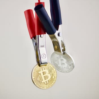 Two hanging cryptocurrency physical coins. Gold and silver bitcoin.