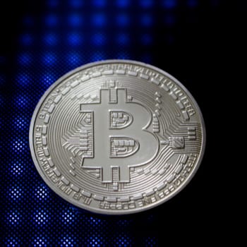 Blue light and silver physical bitcoin coin