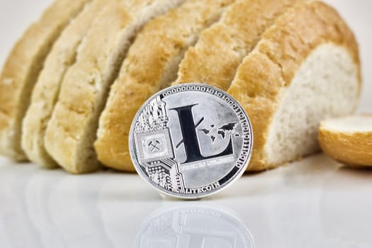 Physical silver cryptocurrency coin and fresh bread