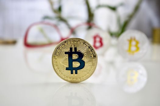 Digital currency physical colored bitcoin coins near pink glasses