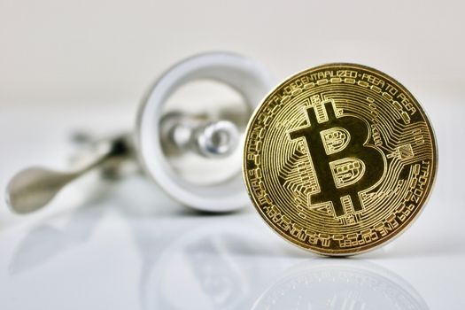 Gold bitcoin physical cryptocurrency coin and silver wine opener.