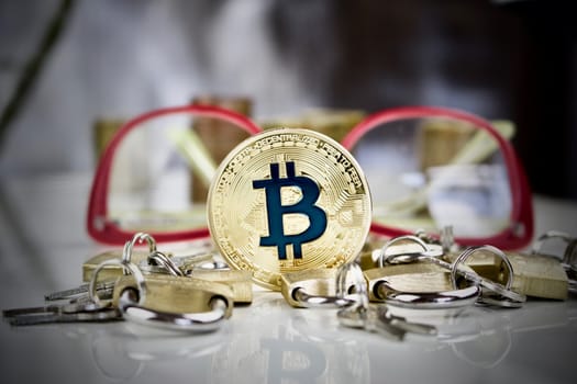 Cryptocurrency physical gold bitcoin coin around padlocks