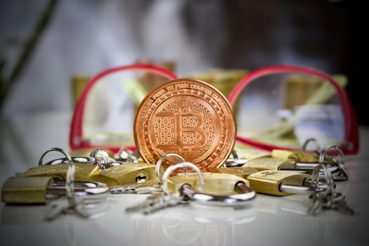 Digital currency physical brass bitcoin coin near gold padlocks