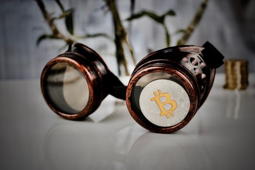 Cryptocurrency physical silver bitcoin coin - steampunk glasses composition