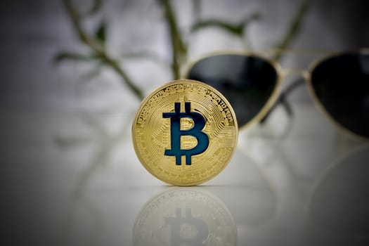 Digital currency physical gold bitcoin coin and gold sunglasses